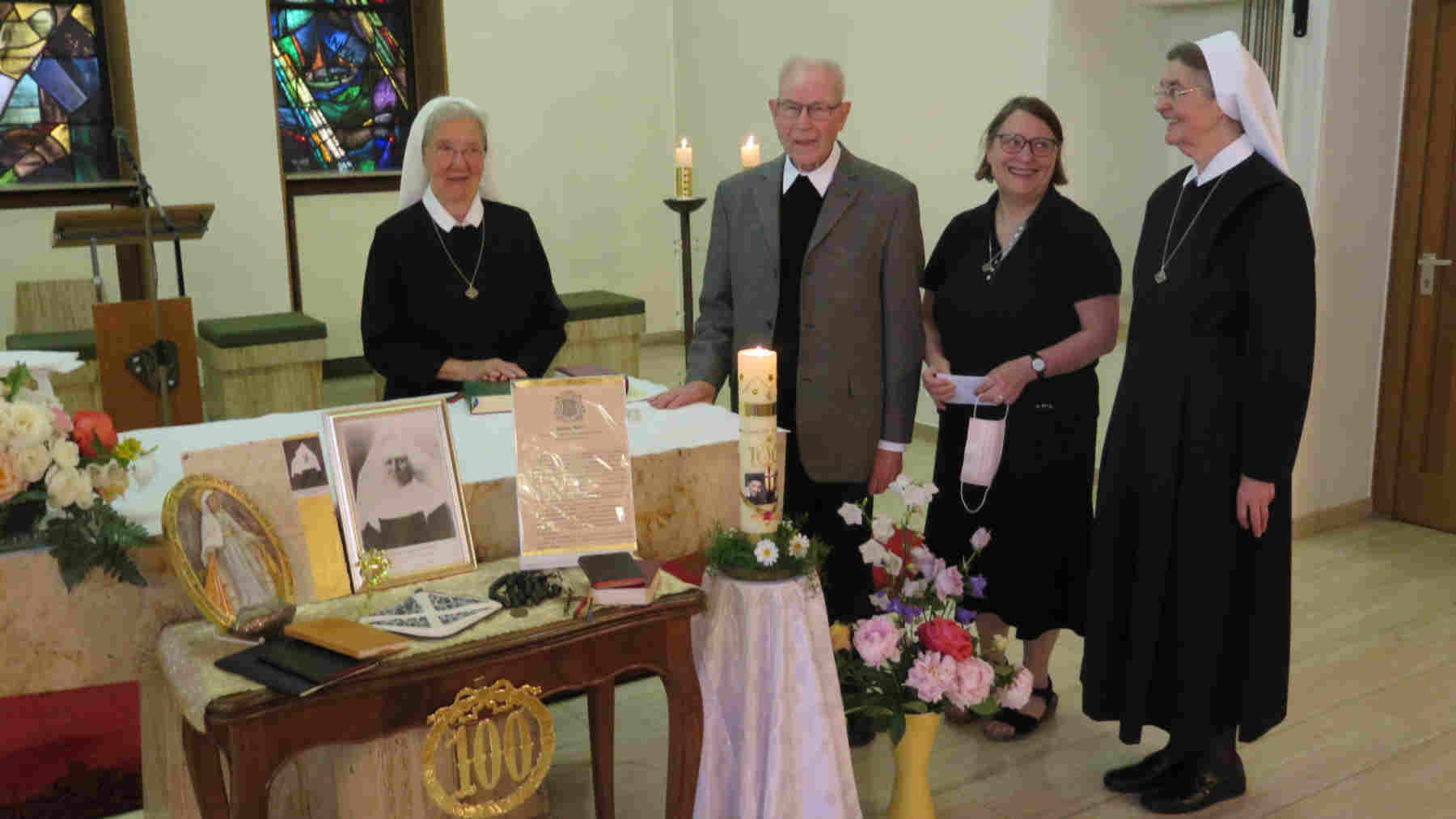 3 Schwestern der Vinzentinerinnen und ein Priester hinter und seitlich am geschmückten Altar der Kapelle der Vinzentinerinnen